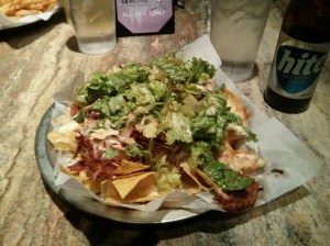 gogi pork nachos with jack cheese, jalapenos, tako salad, sour cream, & spicy korean red sauce.